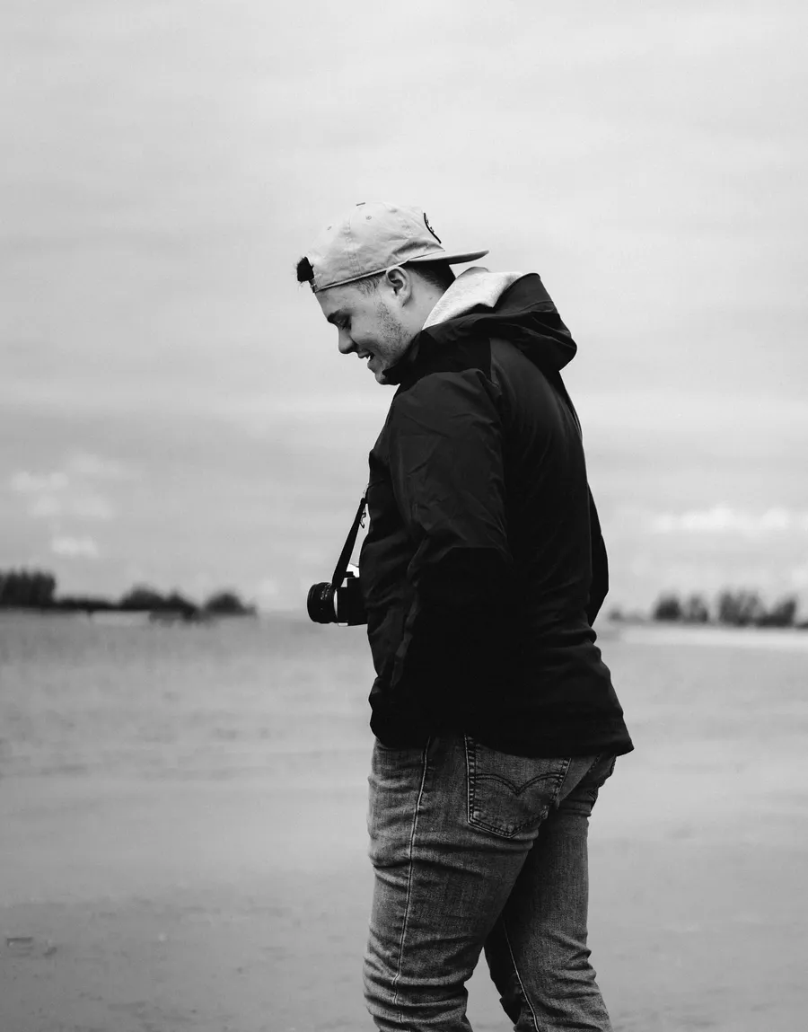 Aaron Rausch, Fotograf, mit Kamera am Strand
